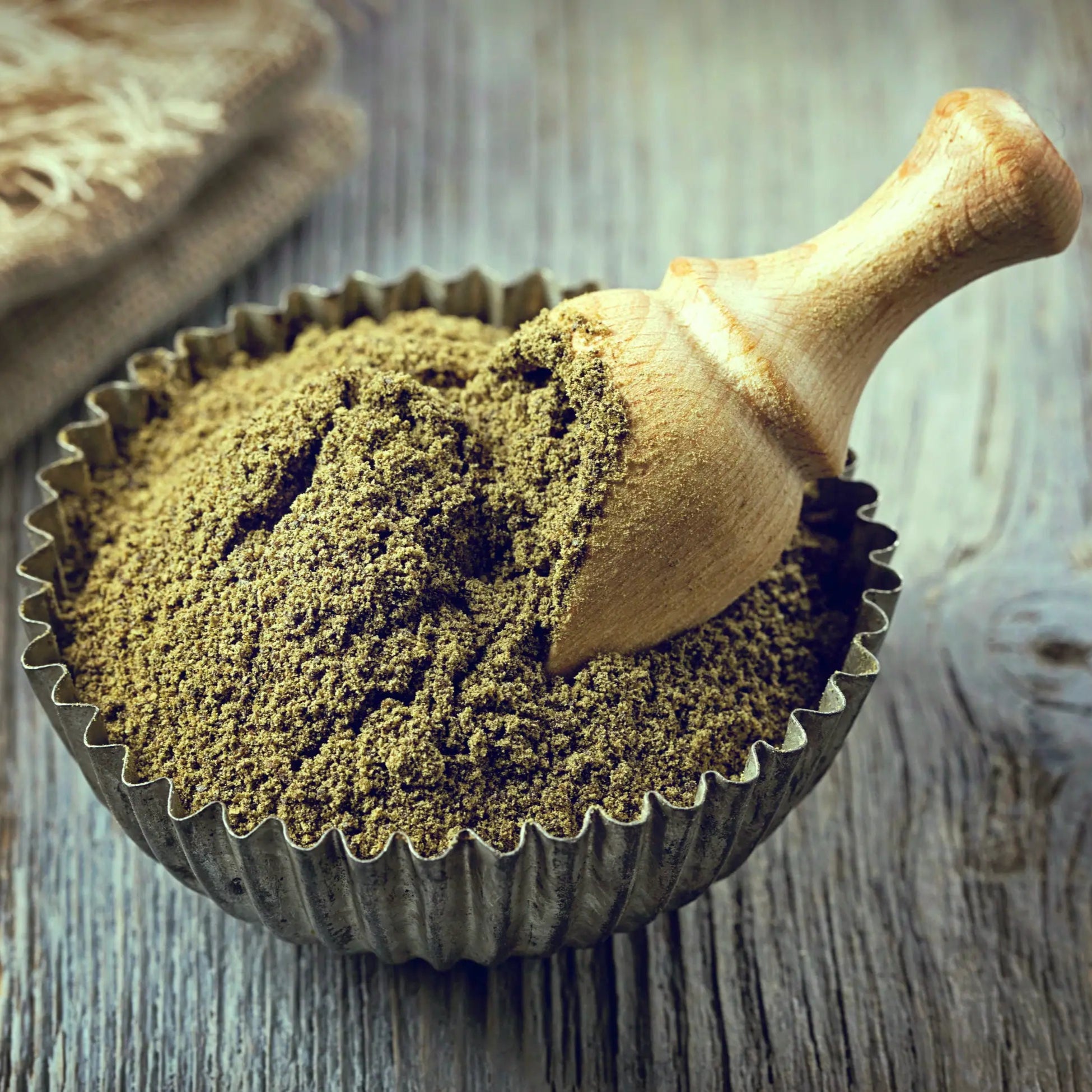 Premium Hanfprotein aus 100% Demeter Hanfnüssen, schonend verarbeitet und biodynamisch erzeugt, präsentiert in einer Vintage-Schale mit einem natürlichen Holzlöffel