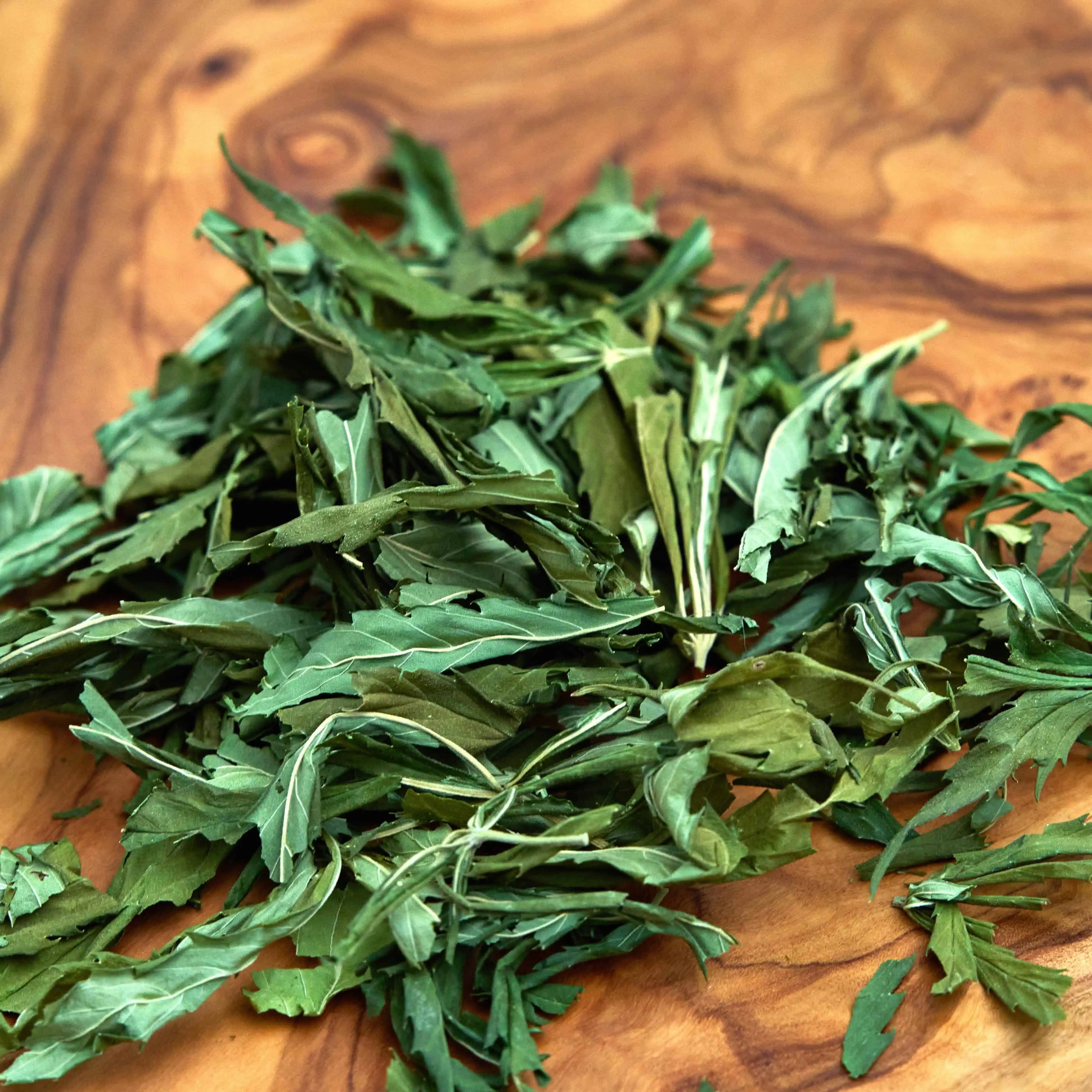 Premium Hanfblätter in Demeter-Qualität vom Lindenhof. Handgepflückt und besonders schonend getrocknet, präsentiert auf edlem Holzbrett